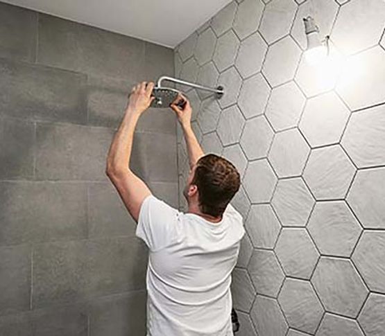Expert worker installing master shower Expert worker installing master shower