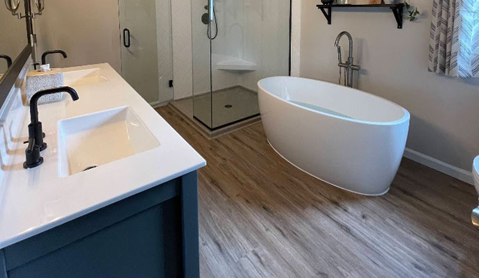 Modern master bathroom with freestanding tub with luxury vinyl flooring