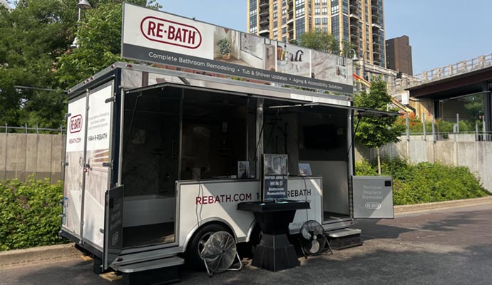 RE-BATH mobile showroom trailer with open display panels parked outdoors