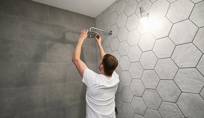 Expert installing shower in bathroom.