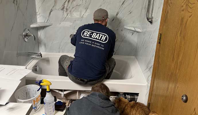 Professional bathroom remodeler installing bathtub