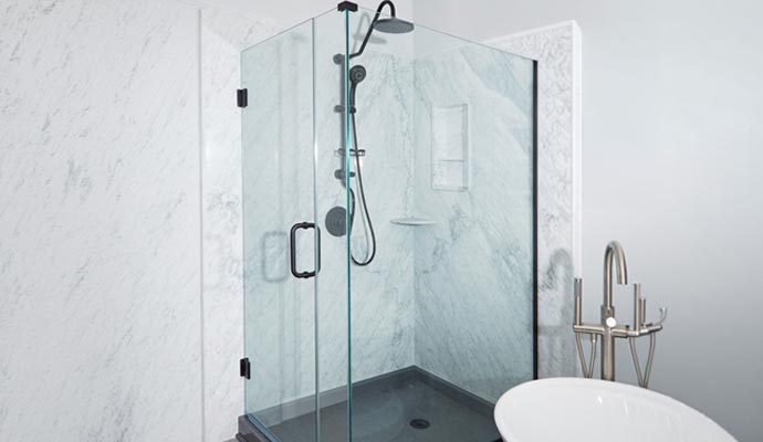 Frameless glass shower enclosure with marble walls