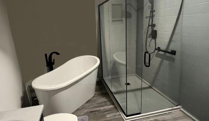 Freestanding bathtub next to glass walk in shower